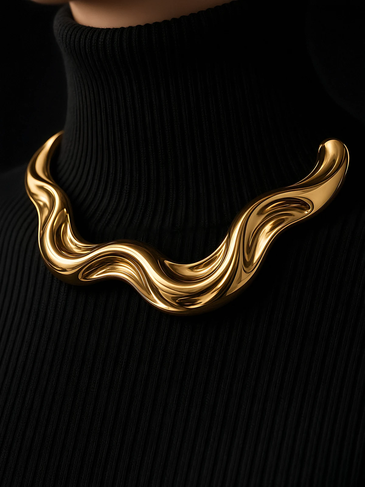A sculptural chunky gold collar necklace on a black ribbed high-neck knit