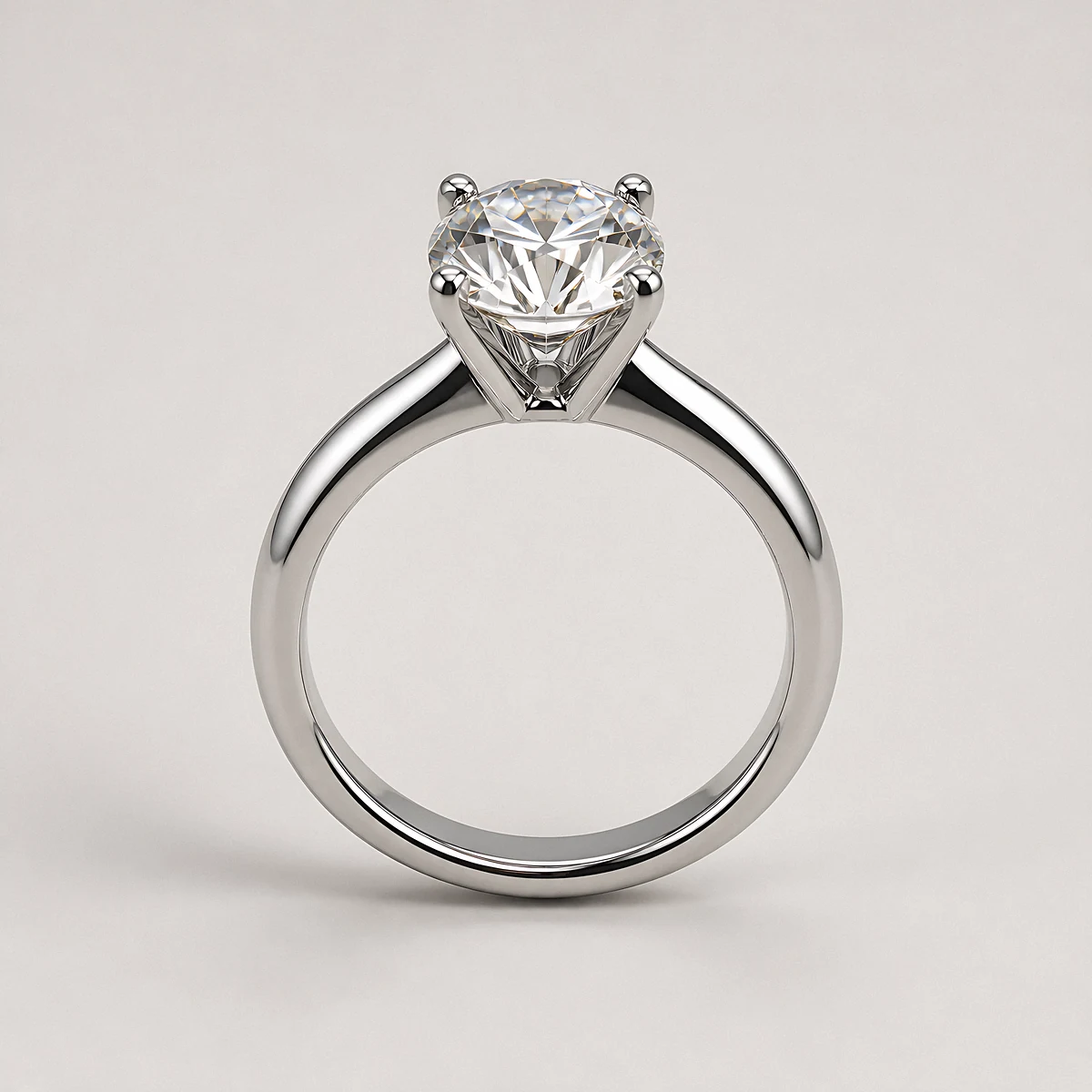 A round brilliant diamond solitaire on a slim platinum band, photographed in the studio