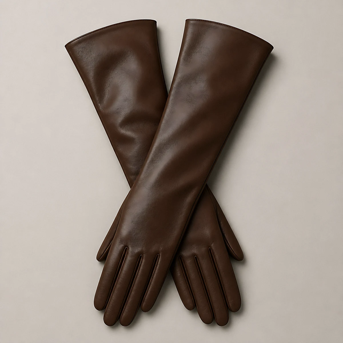 A pair of long chocolate-brown leather opera gloves, photographed in the studio
