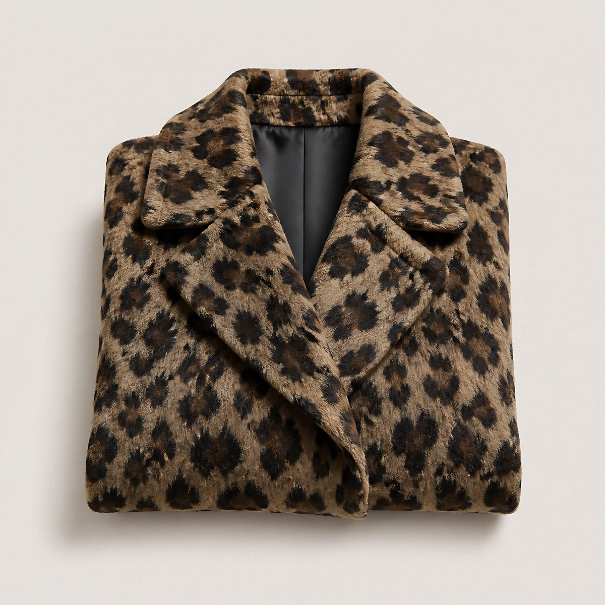 A folded leopard-print coat with a notched collar, photographed in the studio