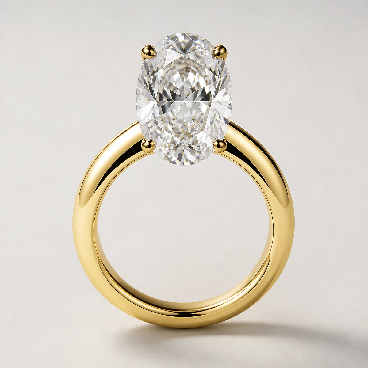A yellow-gold oval diamond solitaire ring on a thick band photographed in the studio